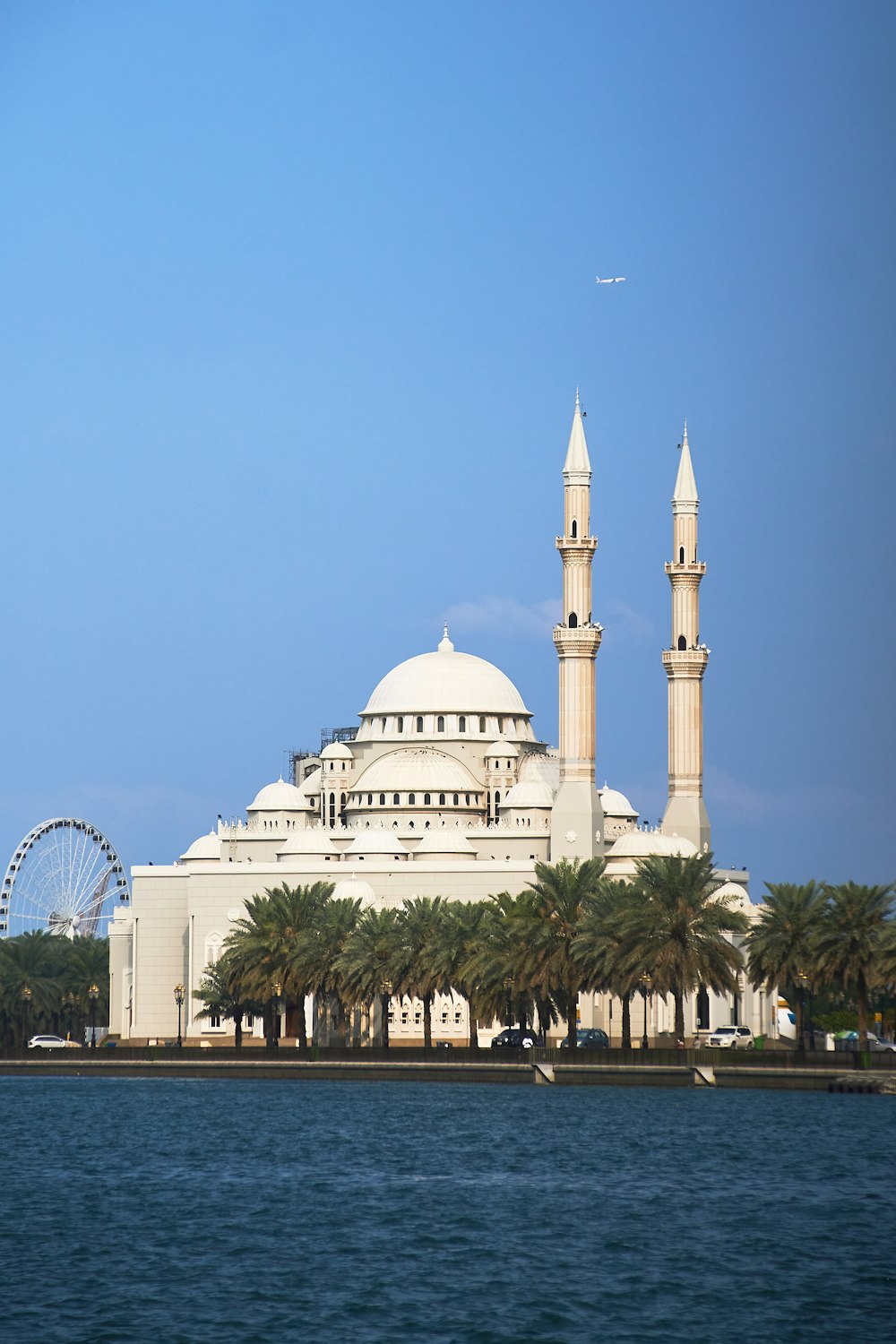 a large white building with a ferris wheel in the background