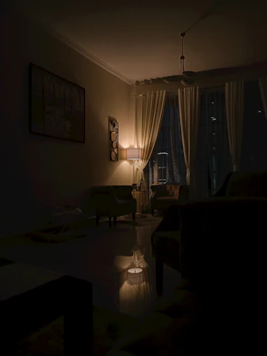 Cozy living room bathed in warm ambient lighting with artistic fixtures casting gentle shadows.