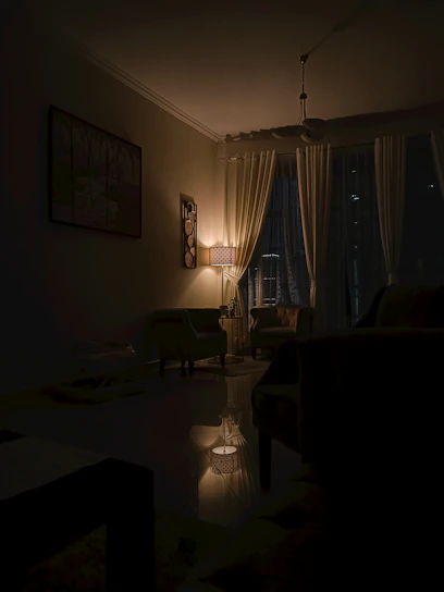 A cozy living room softly illuminated by an elegant Twilight Aura lamp casting a warm glow.