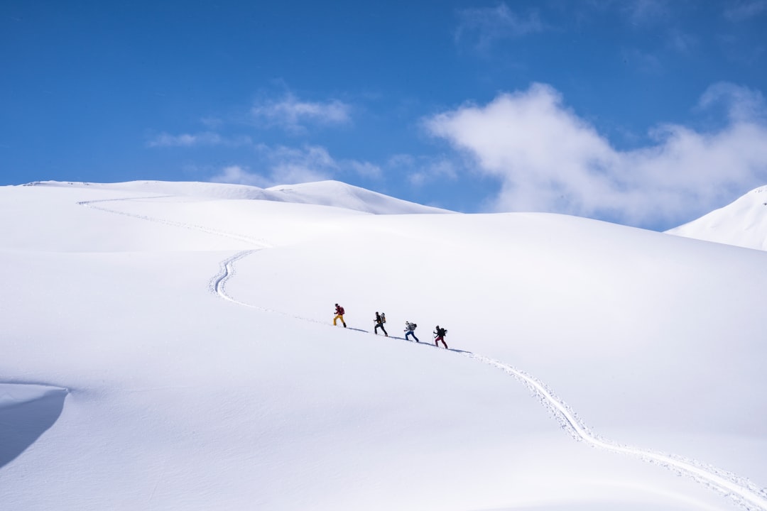 A Group of Skiers Skinning Up To the Border of Italy and Switzerland.
 - unsplash
