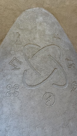 A textured surface features a central atom symbol surrounded by various scientific and technological icons, including a beaker, robotic arm, drone, recycling symbol, and a leaf.