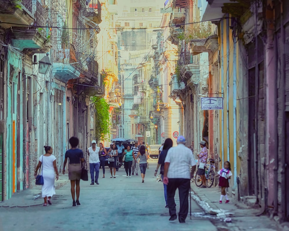 a group of people walking down a street next to tall buildings