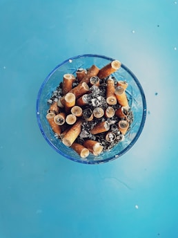 a glass bowl filled with lots of cigarettes