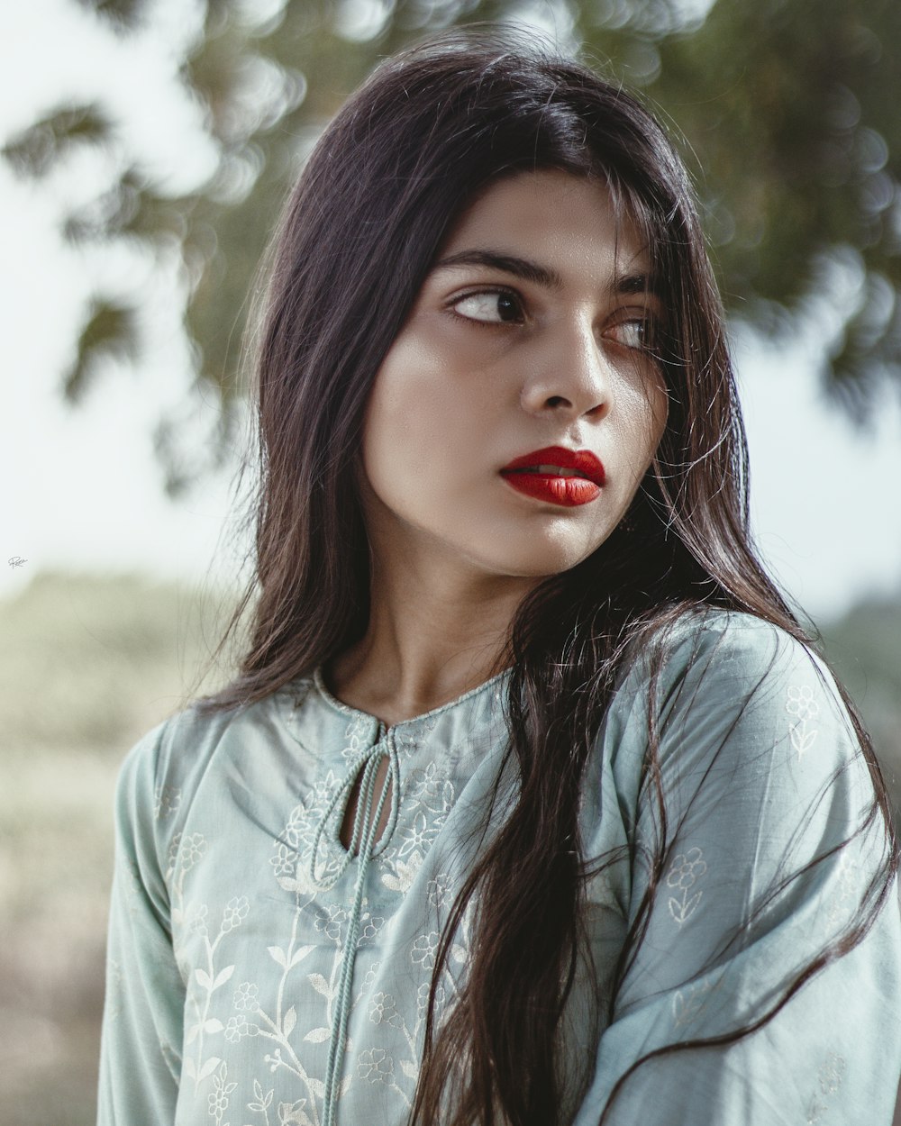 a woman with long dark hair and red lipstick