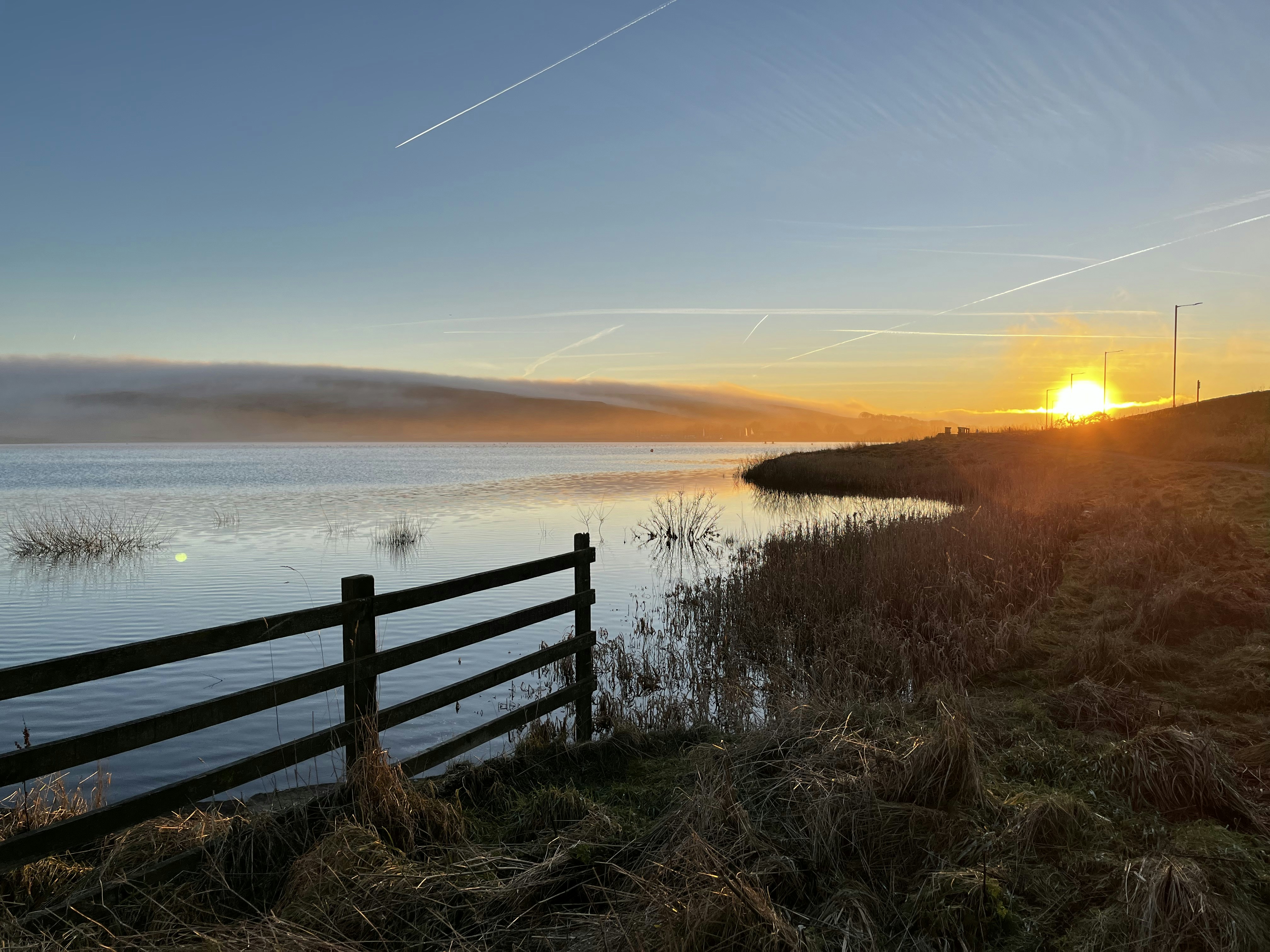 the sun is setting over a body of water