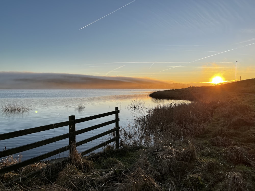 the sun is setting over a body of water