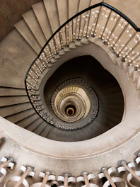 a spiral staircase in a building with white railings