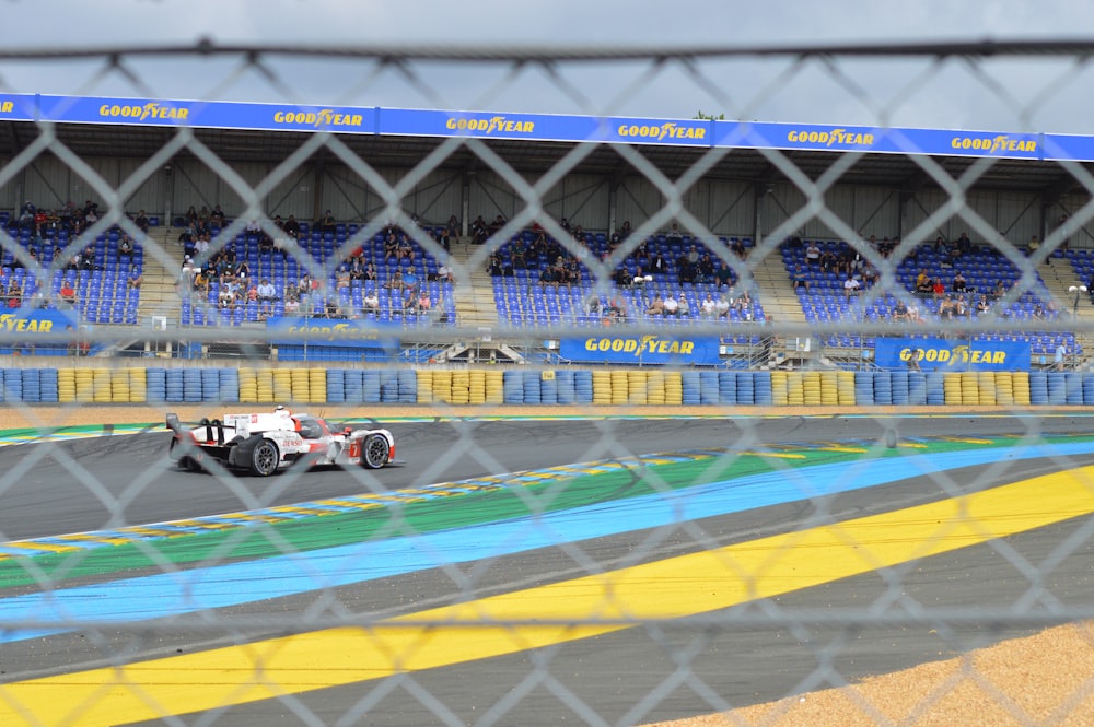 a race car driving around a track in front of a crowd