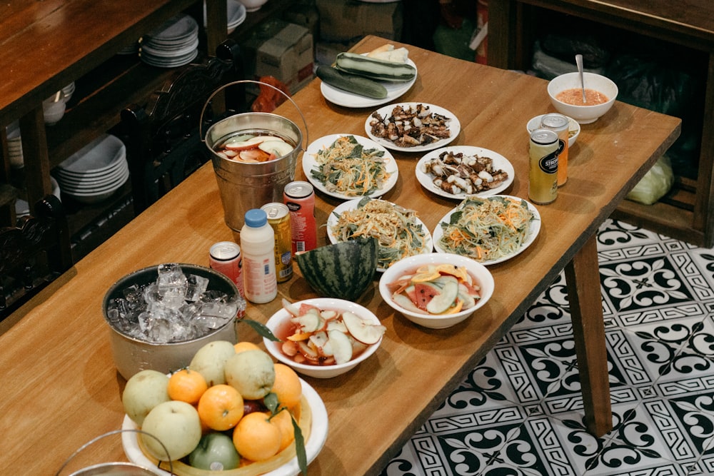 a wooden table topped with bowls of food