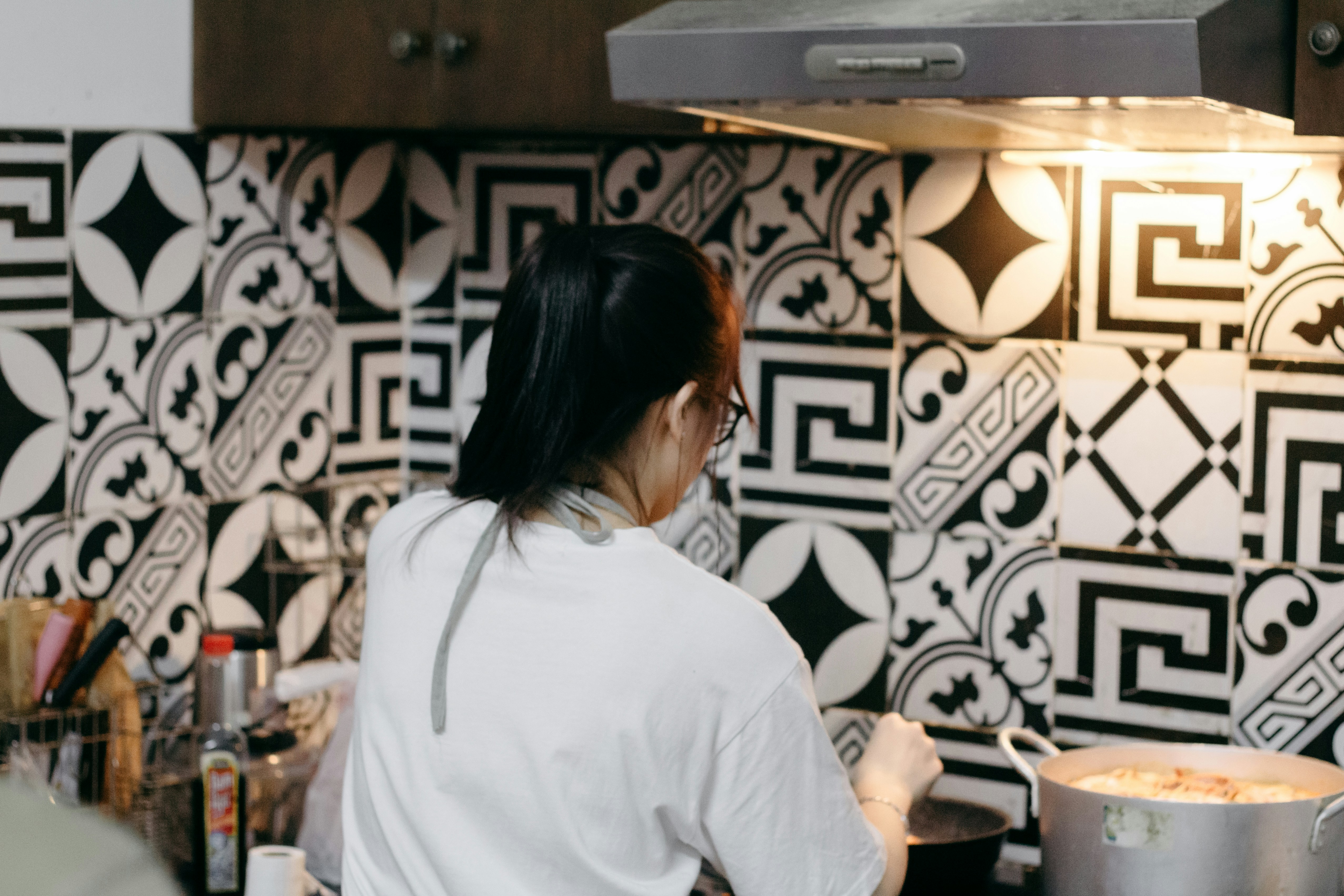 A person happily cooking in a stylish apartment kitchen - fully equipped kitchen rentals