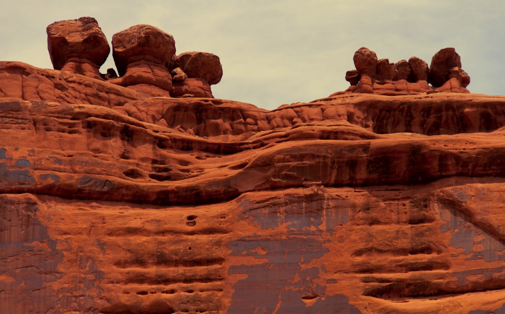 a large rock formation with a sky in the background