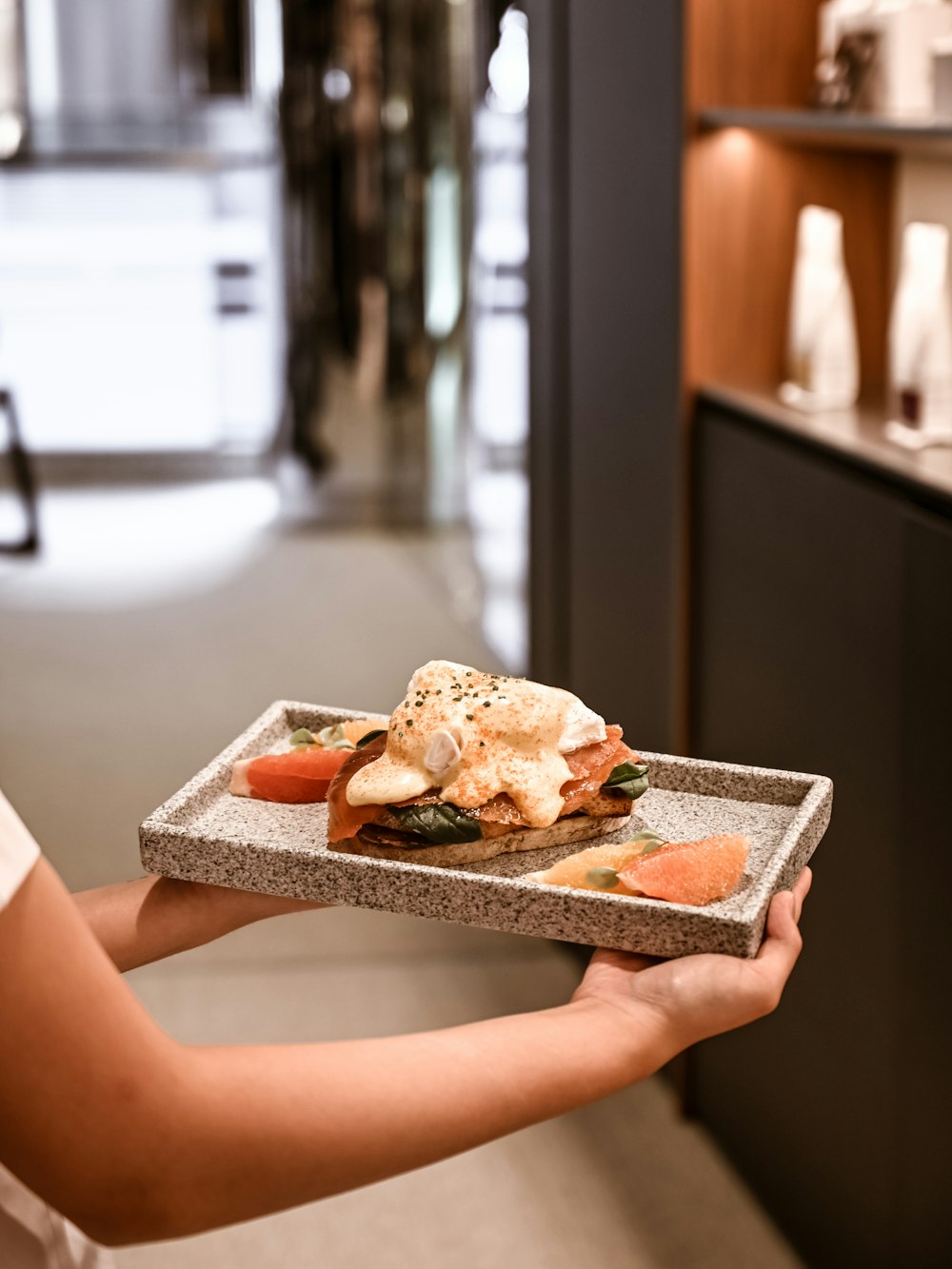 a person holding a tray with food on it