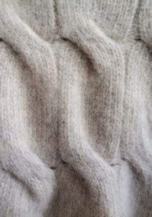 a close up of a person's hand in a sweater