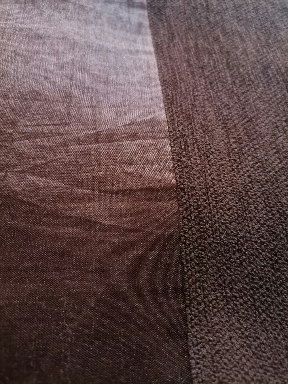 a close up of a bed with a brown bedspread