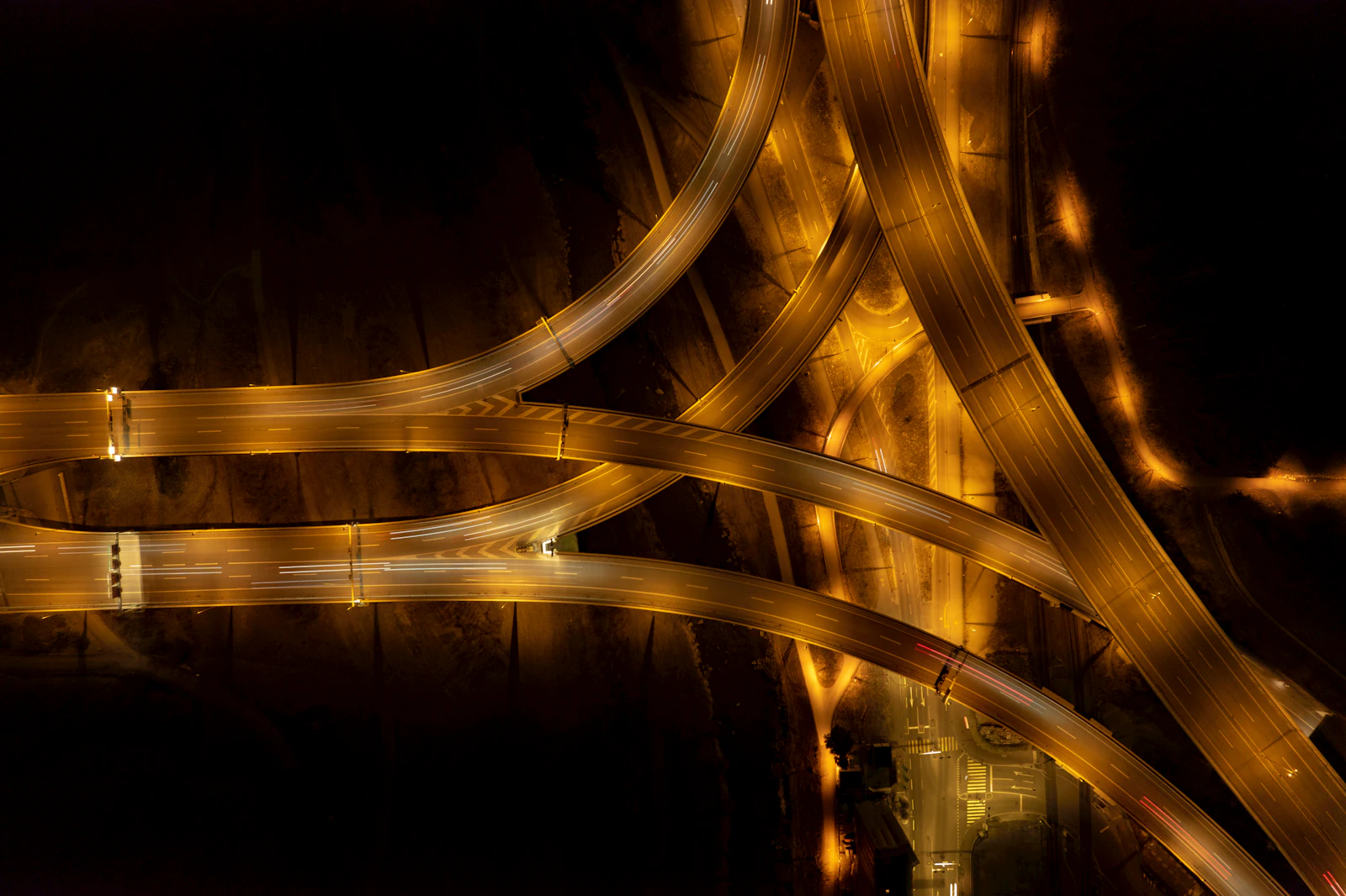 Aerial view of a lit highway interchange at night