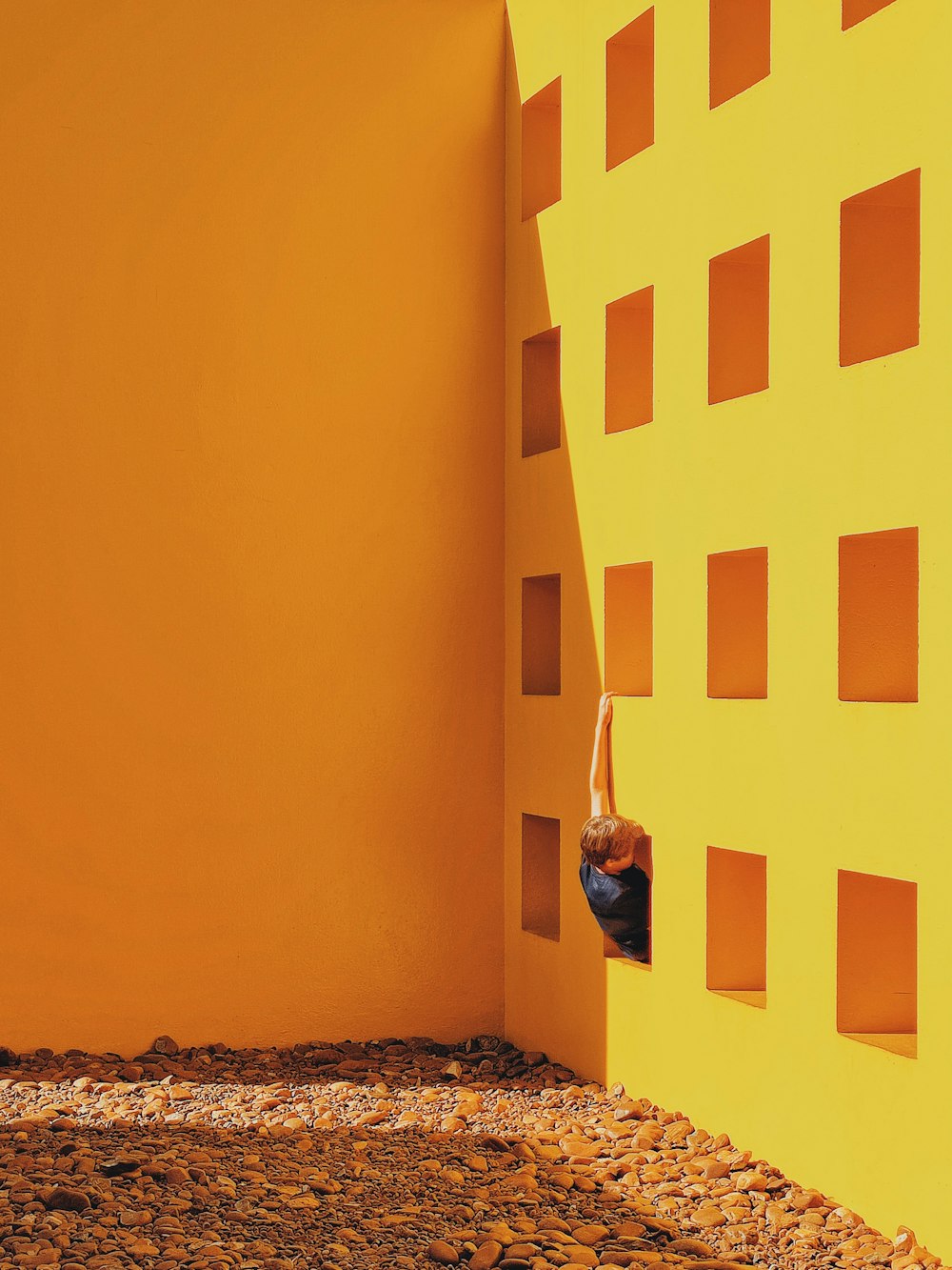 a person climbing up the side of a yellow wall