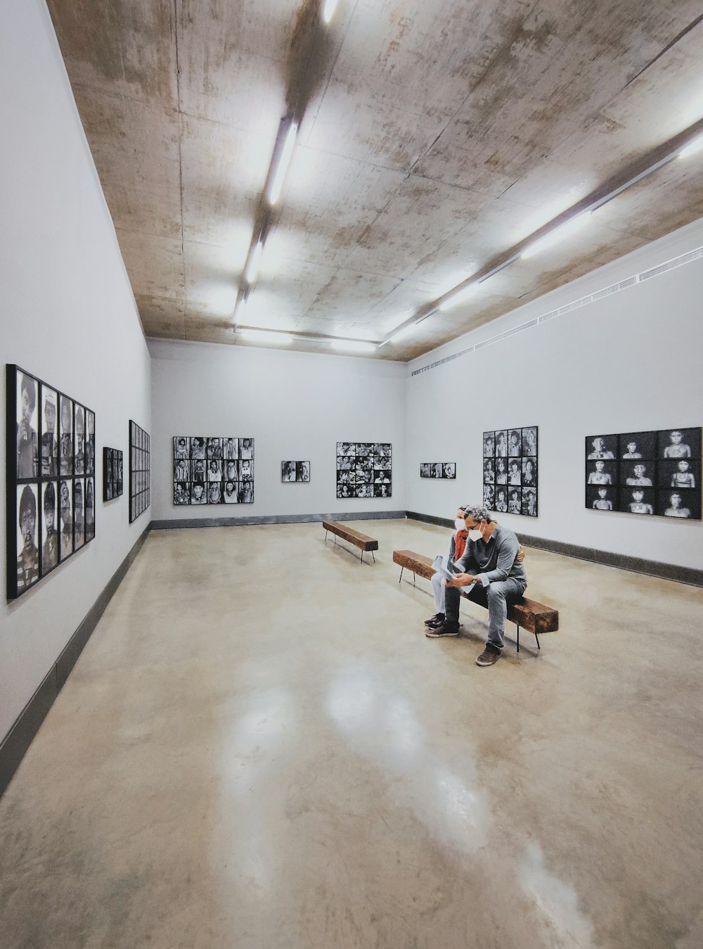 a man sitting on a bench in a large room