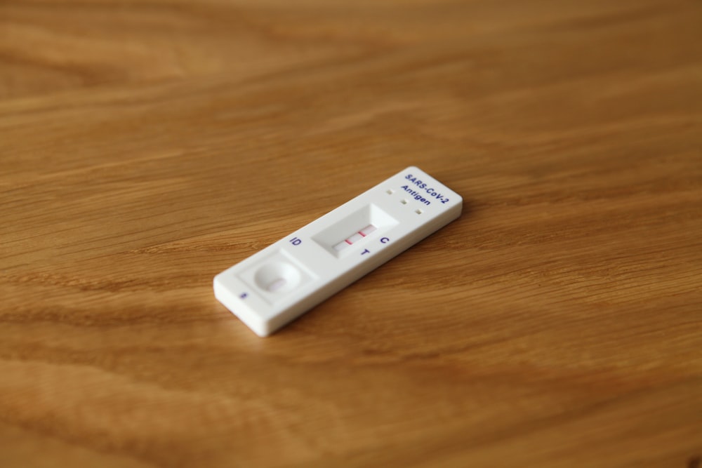 a white remote control sitting on top of a wooden table