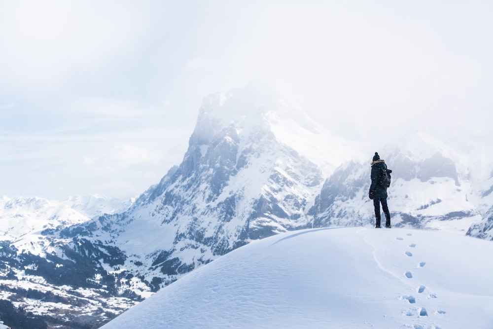 a person standing on top of a snow covered mountain