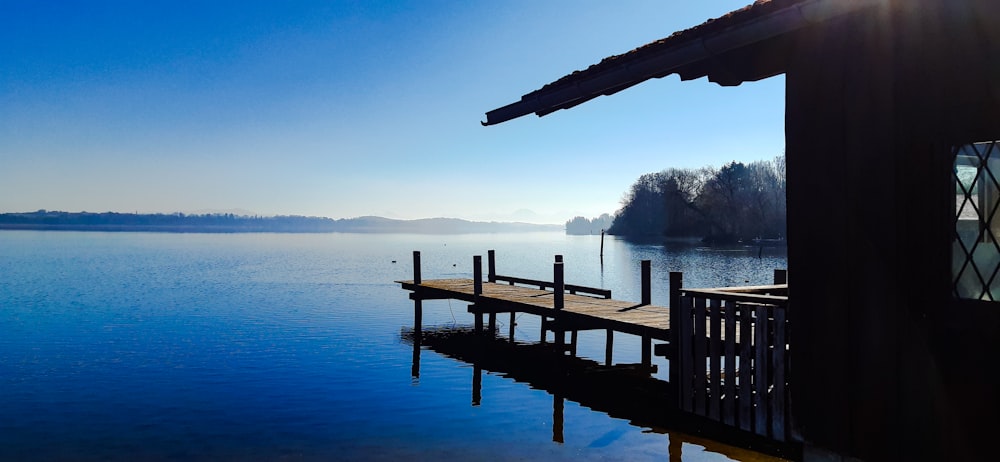 a dock on a lake with a house in the background