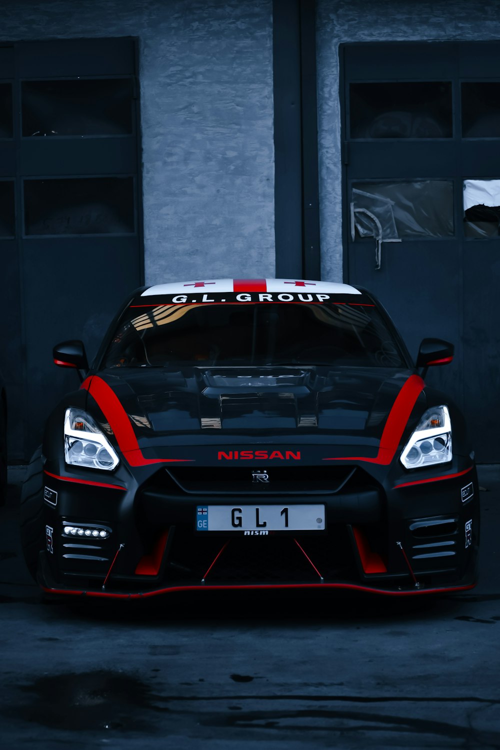 a black and red sports car parked in front of a building