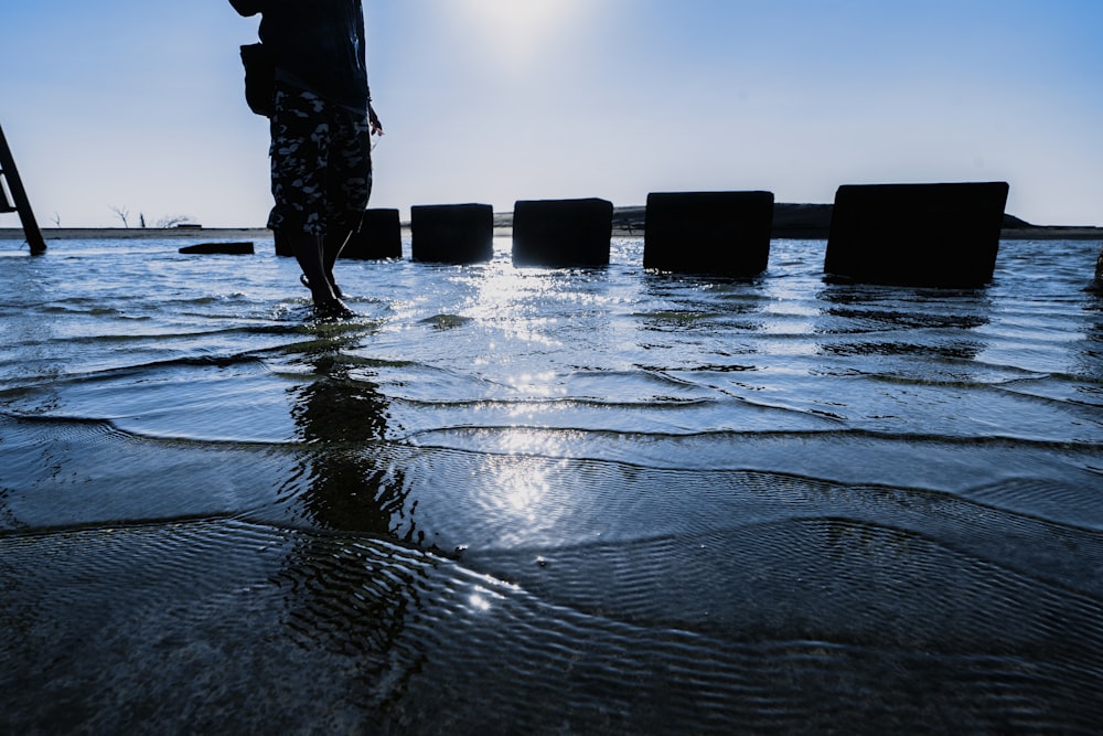 a person standing in the water with an umbrella