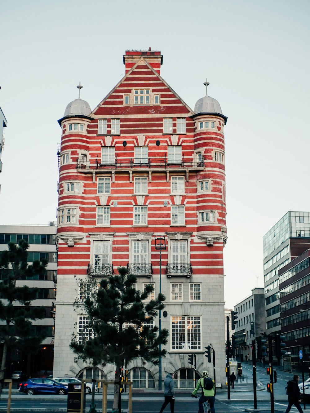 Un alto edificio de ladrillo rojo sentado al costado de una calle