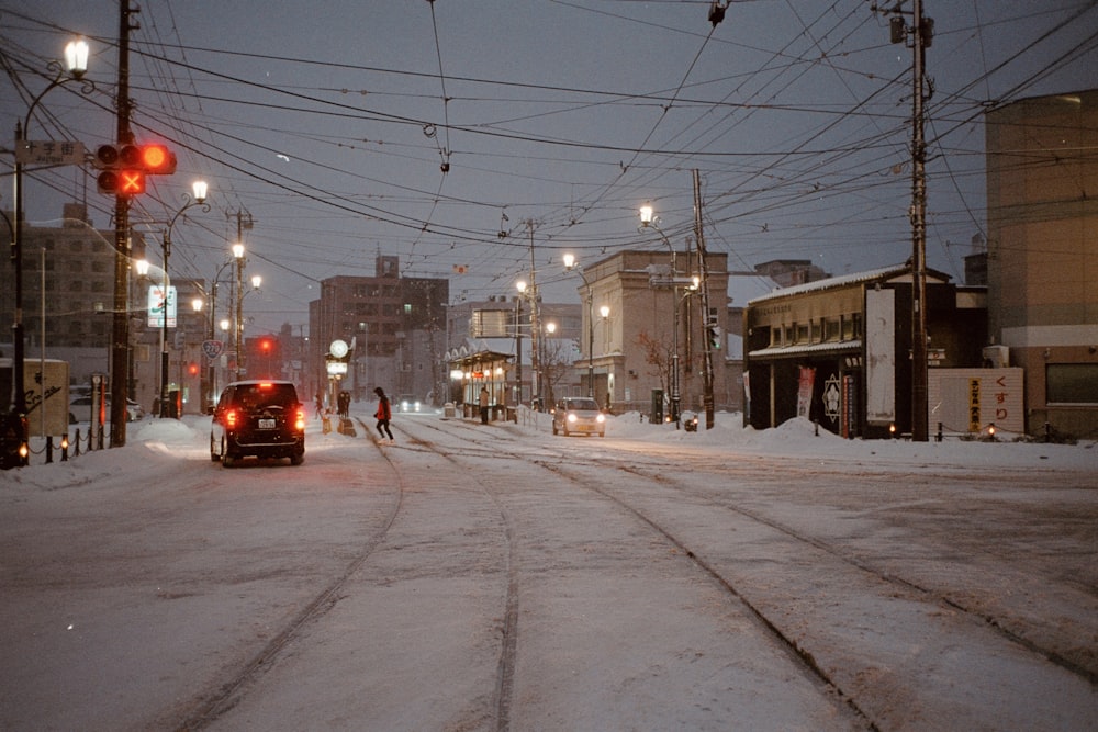 um carro dirigindo por uma rua coberta de neve