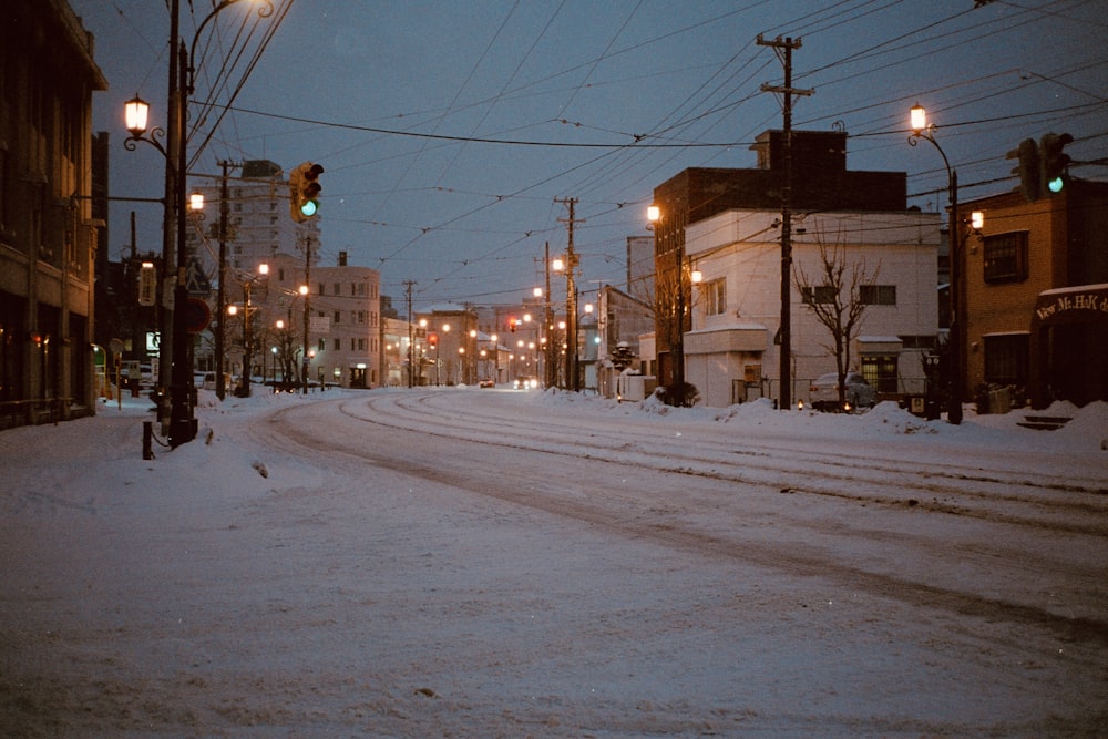 a city street is covered in snow at night