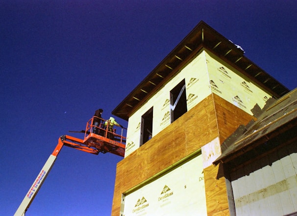 a man on a cherry picker working on a building