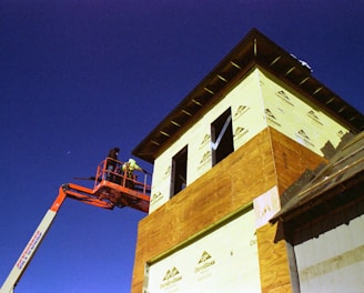 a man on a cherry picker working on a building