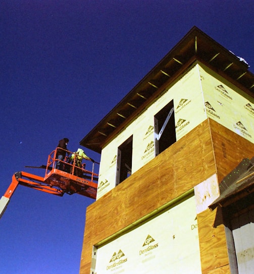 a man on a cherry picker working on a building