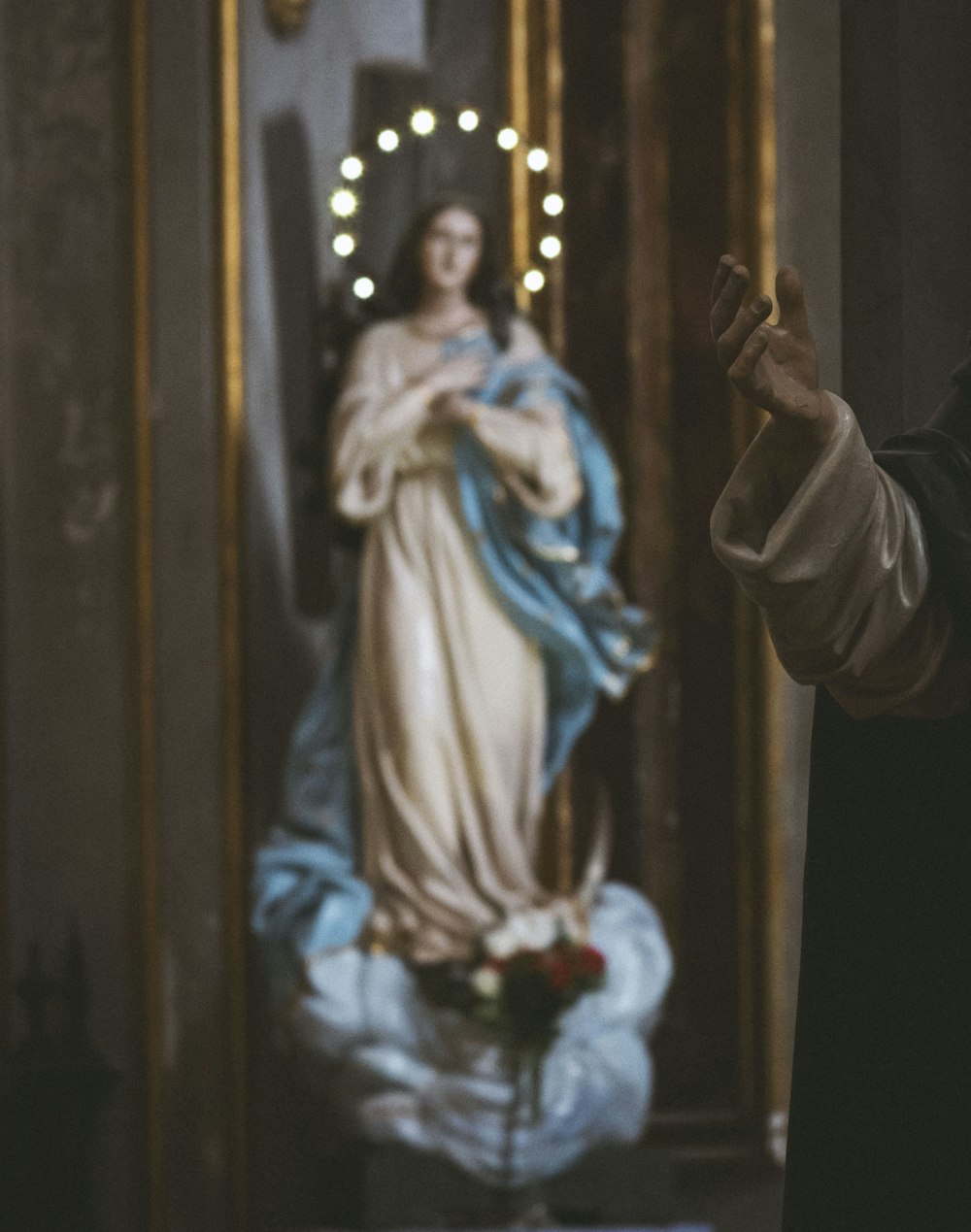 a statue of the virgin mary in front of a mirror
