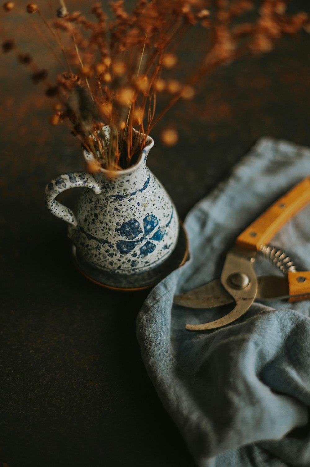 a blue and white vase sitting on top of a table next to a pair of