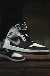 Close-up of a trendy sneaker with bold design details on a concrete sidewalk.