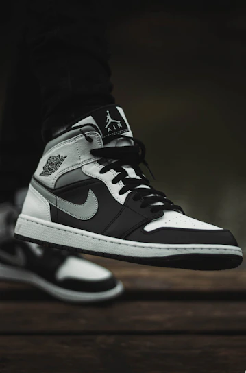 Close-up of a stylish Stepora shoe resting on a wooden bench, highlighting its unique rubber and leather design.
