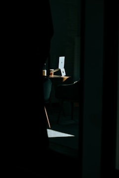Soft morning light over a desk with a laptop and coffee.