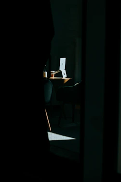 A sleek newsroom desk with a laptop, notes, and a cup of coffee, bathed in soft morning light.