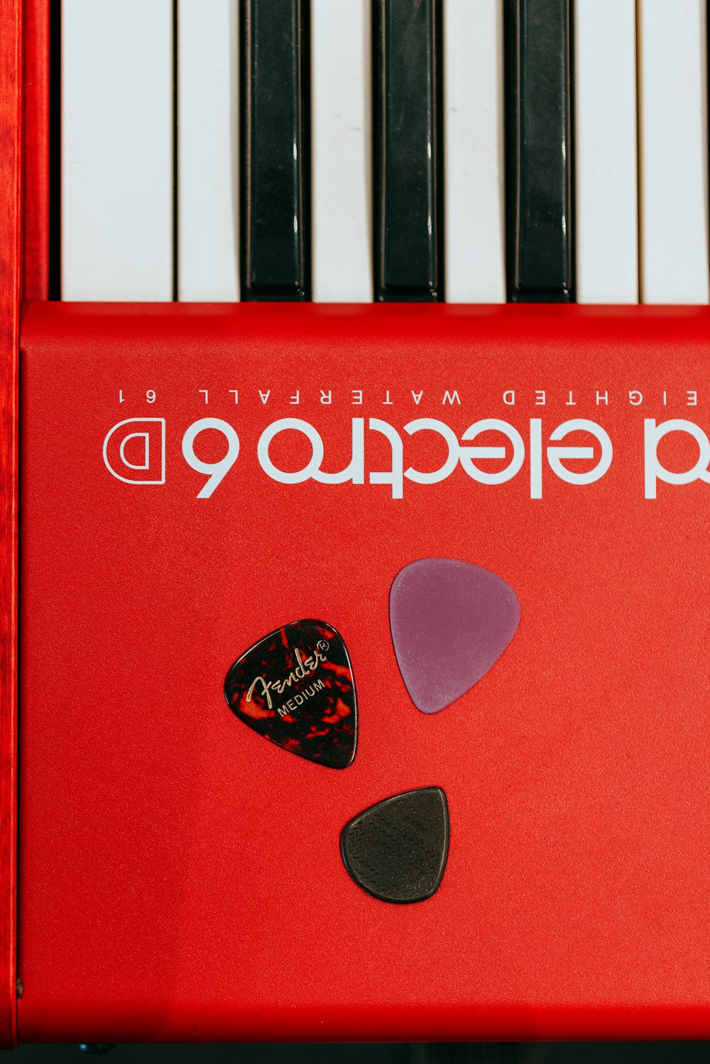 a close up of a piano with a guitar pick