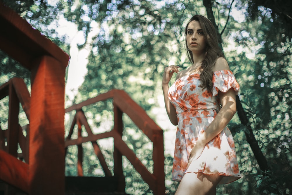 a woman in an orange and white dress posing for a picture