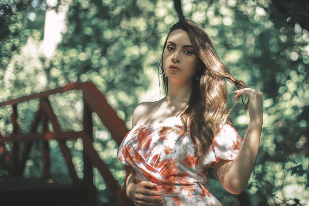 a woman with long hair standing in the woods