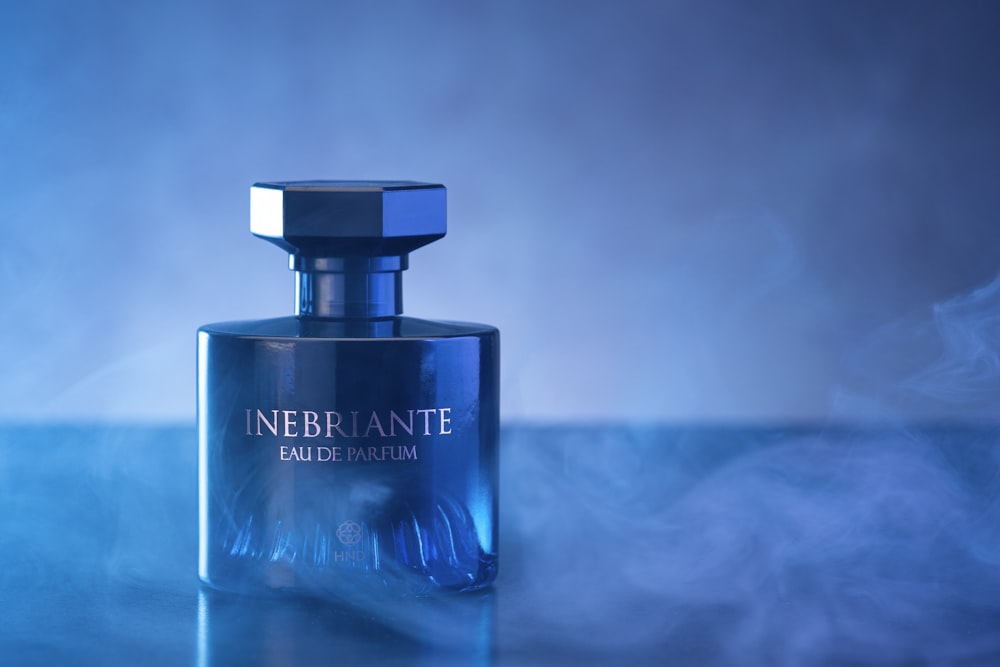 a blue bottle of perfume sitting on a table