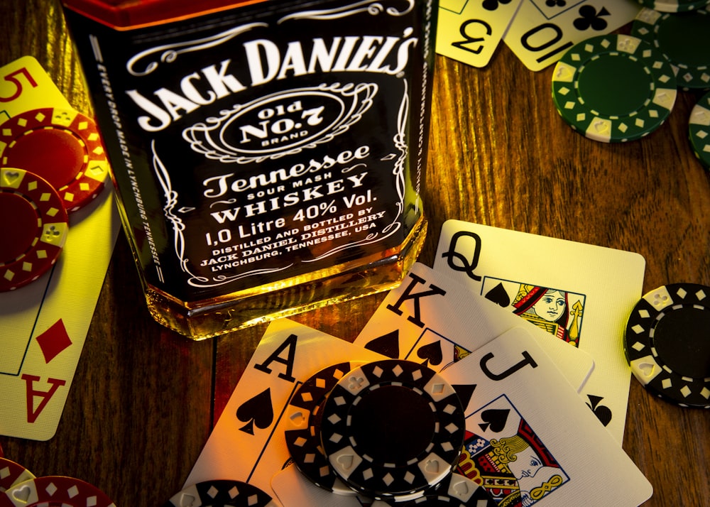 Una botella de Jack Daniels sobre una mesa con naipes