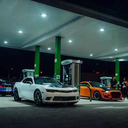 a couple of cars are parked at a gas station