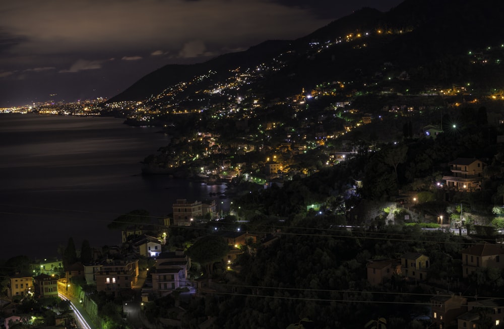 a night time view of a city by the ocean