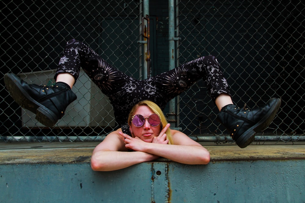 a woman wearing sunglasses laying on the ground