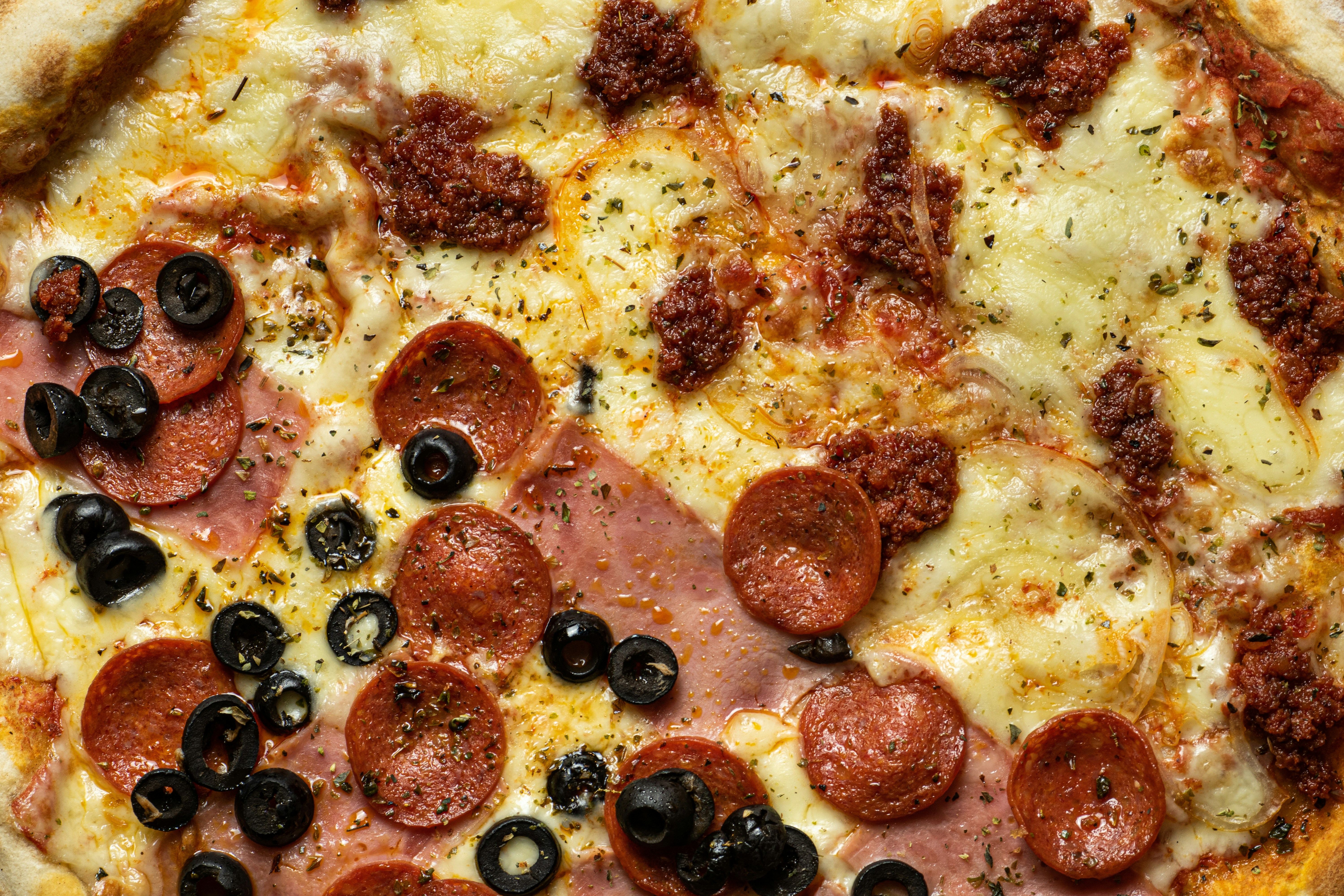 a pizza with pepperoni, olives, and ham