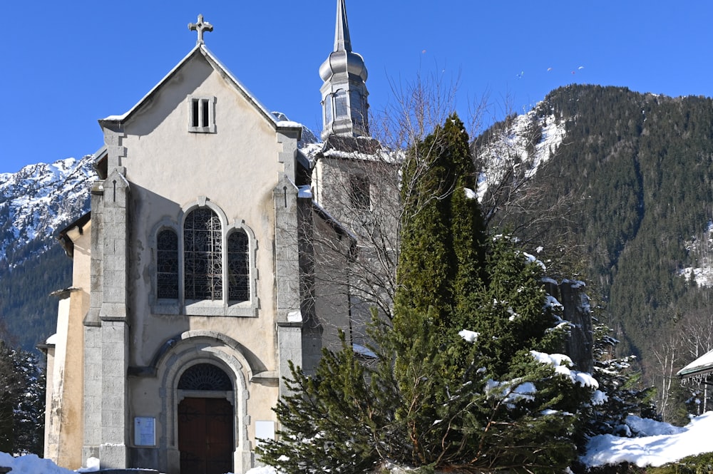 a church with a steeple surrounded by snow