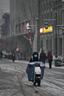 A lively street scene with a Scoot Scoot rider zipping past snow-covered sidewalks, blending urban life with winter.