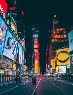 a busy city street at night with neon signs